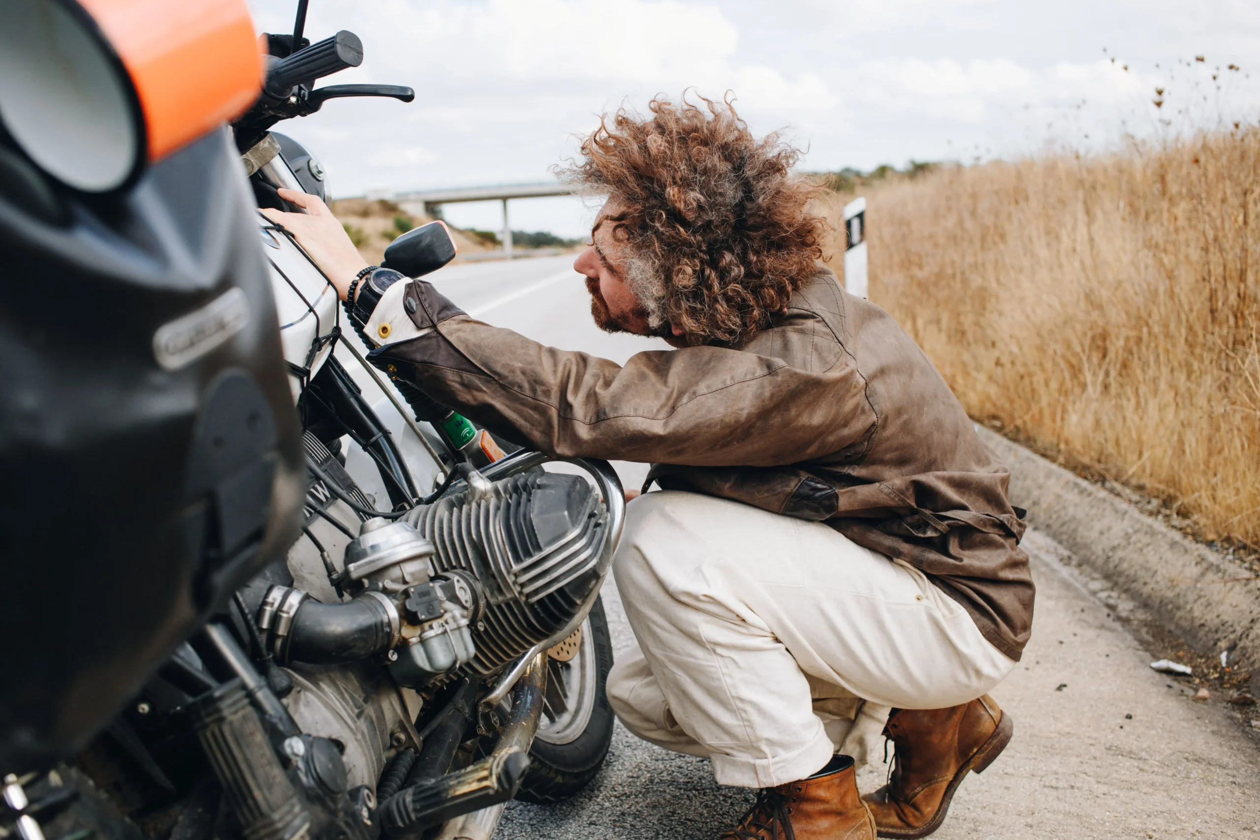 el-hombre-intenta-arreglar-la-moto-al-costado-de-la-carretera